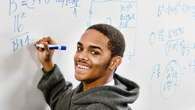 Portrait of smart african american student solving mathematics o